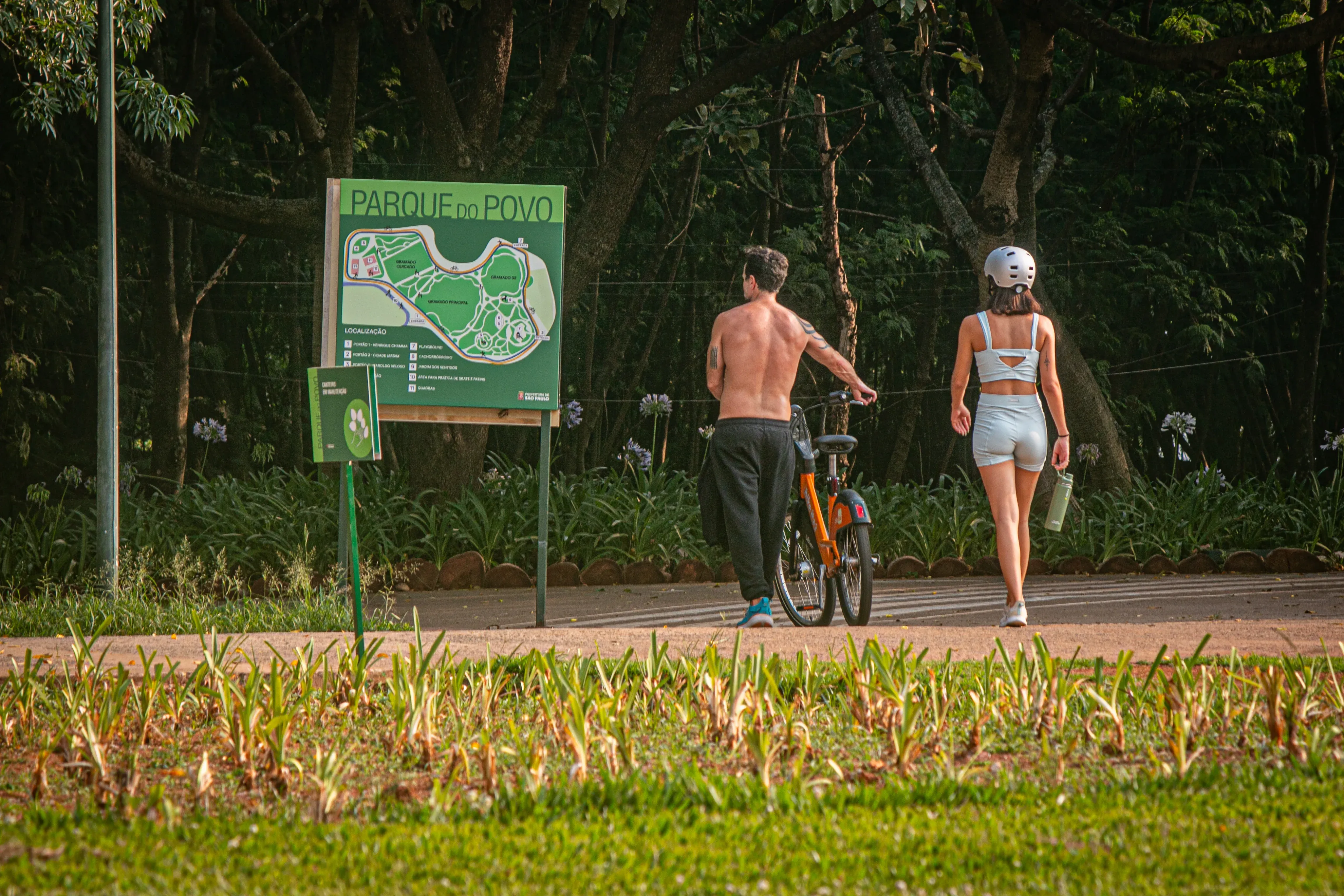 Cyclist and woman in sportswear near at Parque do Povo